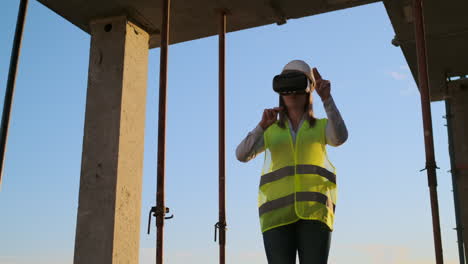 Eine-Ingenieurin-Auf-Einer-Baustelle-Mit-Einer-Virtual-Reality-Brille-Bewegt-Ihre-Hände-Und-Simuliert-Die-Arbeit-An-Der-Schnittstelle-Der-Zukünftigen-Innovativen-Steuerung-Des-Baus-Von-Gebäuden